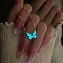 Collier papillon Lumina porté, glow bleu la nuit